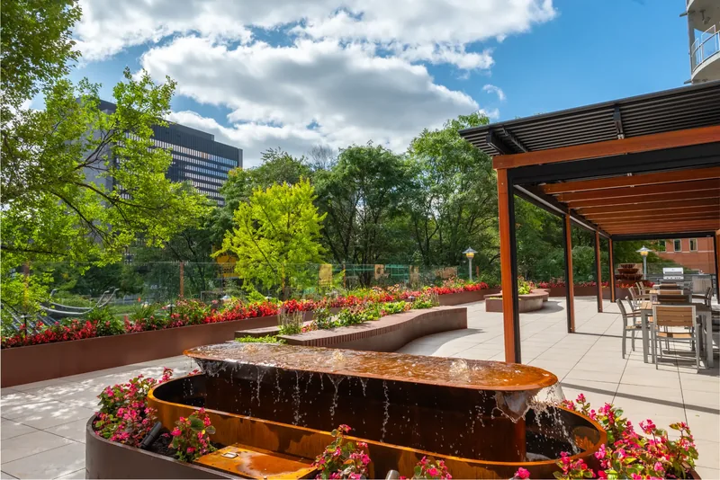 Steel water feature surrounded by flowers on the terrace