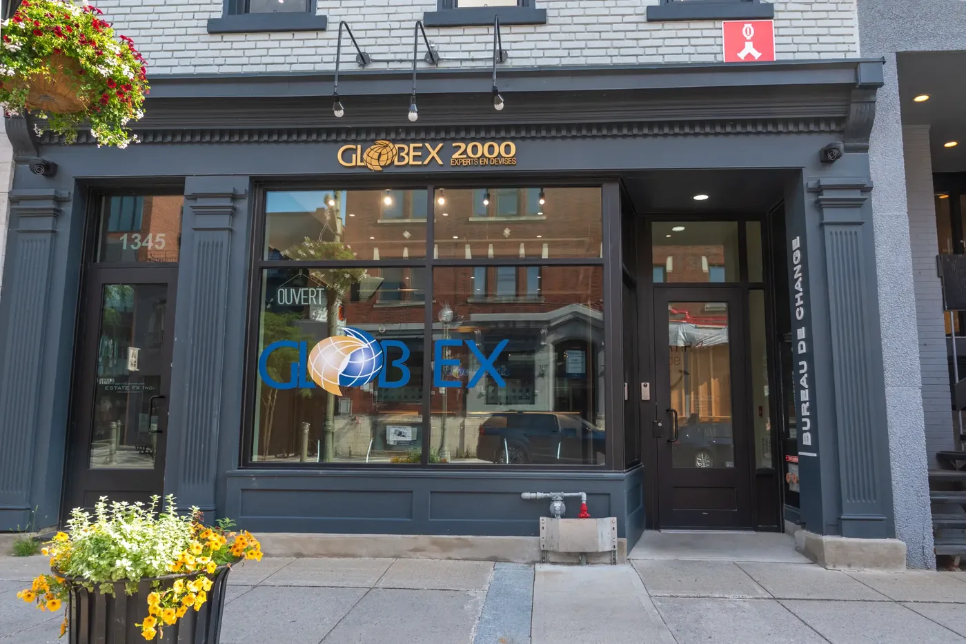 Globex 2000 storefront with charcoal-blue millwork, fluted pilasters, gold lettering, and large display windows