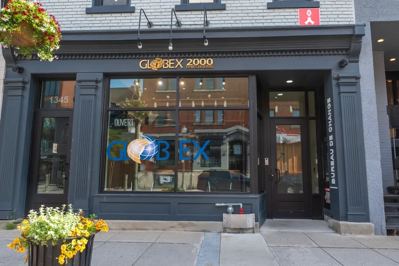 Globex 2000 storefront with charcoal-blue millwork, fluted pilasters, gold lettering, and large display windows