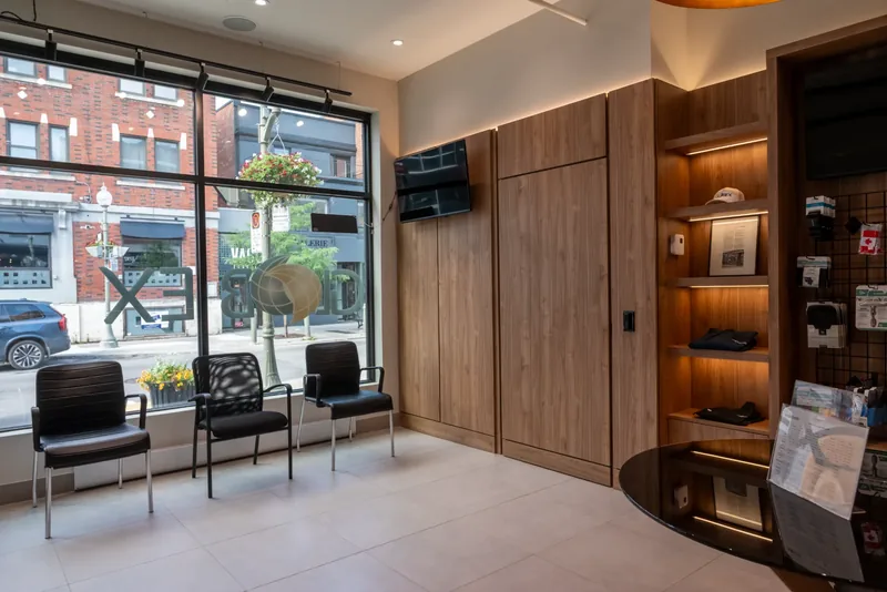 Window seating along the storefront glass beside wood-panelled walls and lit display shelves