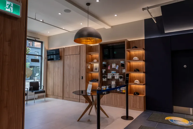 Client floor with wood panelling, lit shelving, a dome pendant, and window seating along the street