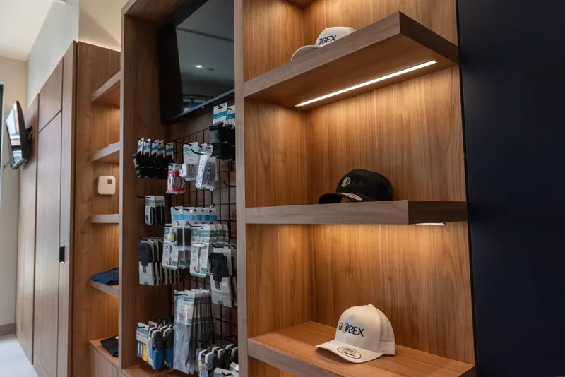 LED-lit wood shelves displaying Globex caps beside a pegboard of travel accessories