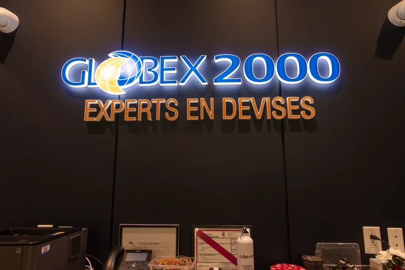 Backlit Globex 2000 Experts en devises sign on a dark wall in the teller area
