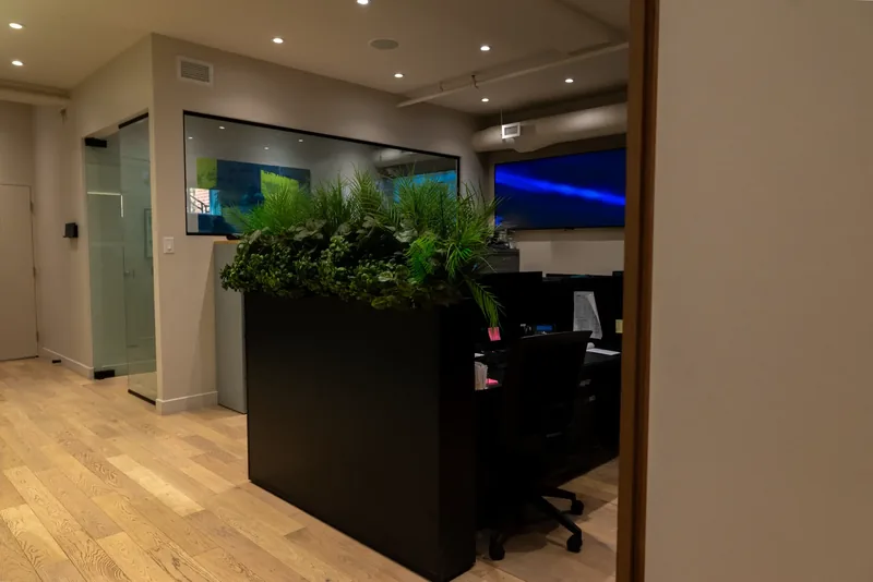 Entry to the operations room, with a glass door, light oak floor, and a planter divider