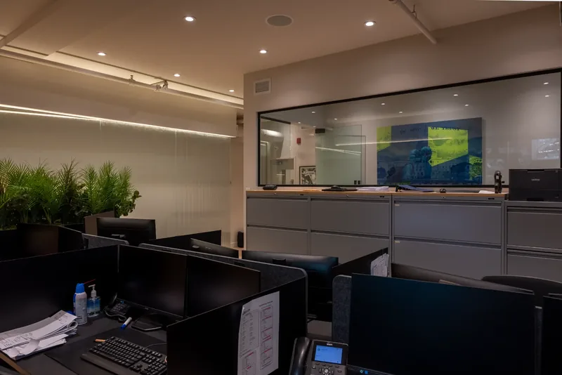 Open office with workstations, lateral filing, and a glazed interior window