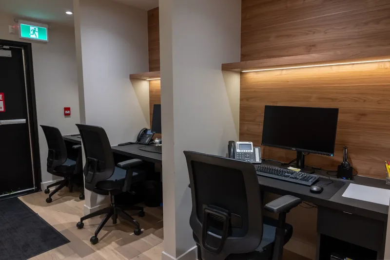 Workstations set against a wood-panelled wall with an integrated lit ledge