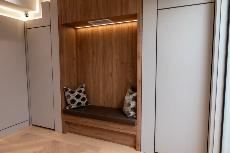 Wood-lined alcove with a cushioned bench and concealed lighting