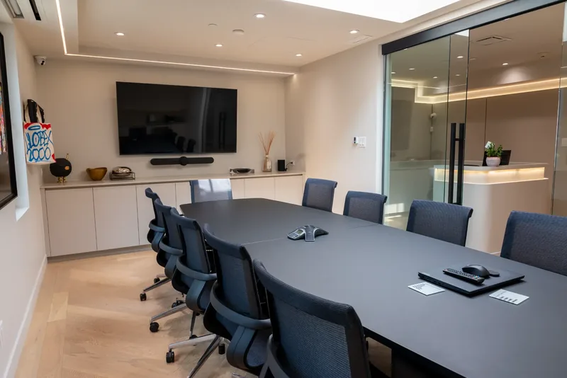 Boardroom table with low white credenzas and a glass door to the reception