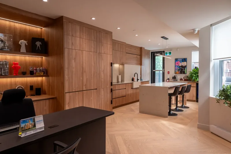 Herringbone oak floor leading from an executive office to the kitchen island