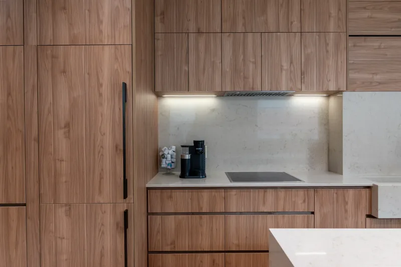 Wood cabinetry framing a stone backsplash and cooktop