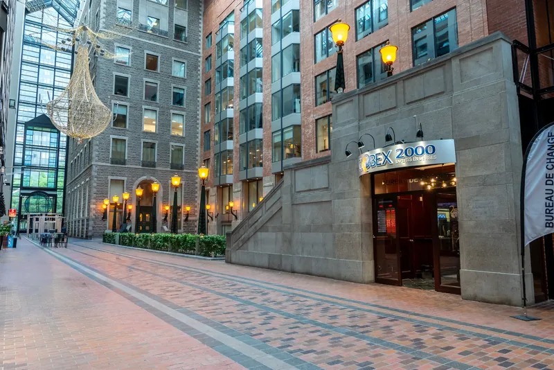 Branch entrance on the atrium's brick-paved promenade, with lanterns and a suspended light installation