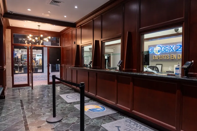 Teller windows with glass partitions, green marble counters, and mahogany-toned panelling
