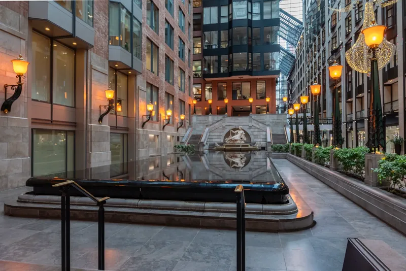 Sculpted fountain and still water reflecting the lanterns at the end of the atrium