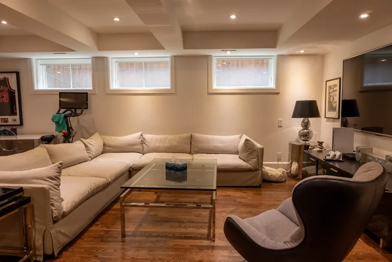 Lower-level lounge with a coffered ceiling and a sectional sofa