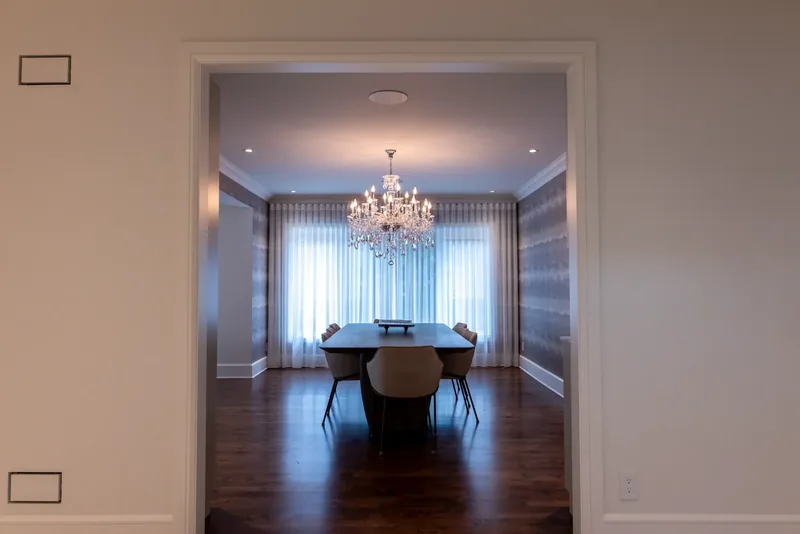 Dining room with a crystal chandelier, textured wallcovering, and a long table
