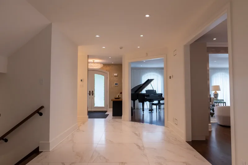 Entrance hall with marble-look floors opening onto the living room and grand piano