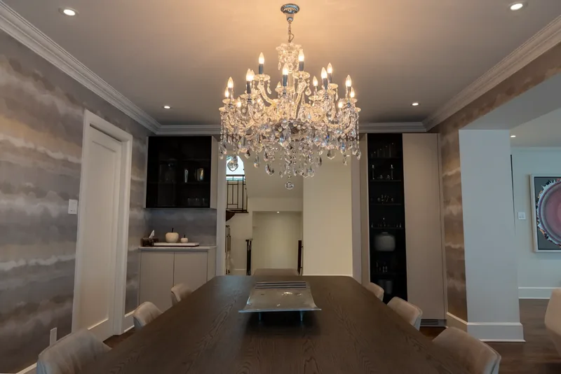 Dining room with a crystal chandelier, textured wallcovering, and a long table