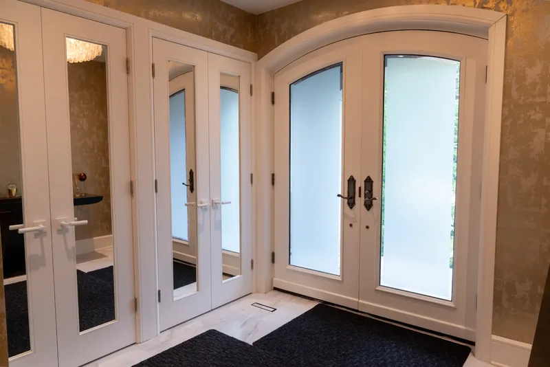 Arched double front doors with frosted glass in the entrance foyer