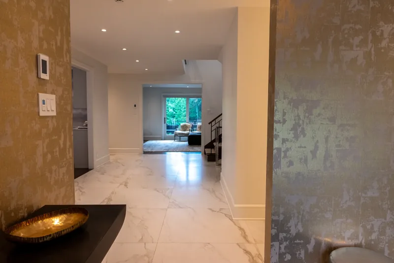 Foyer with a gold-leaf textured wall and a black floating console