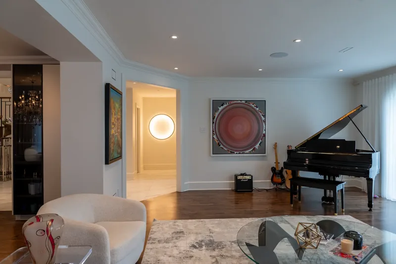 Living room with a grand piano, arched windows, and sheer drapery