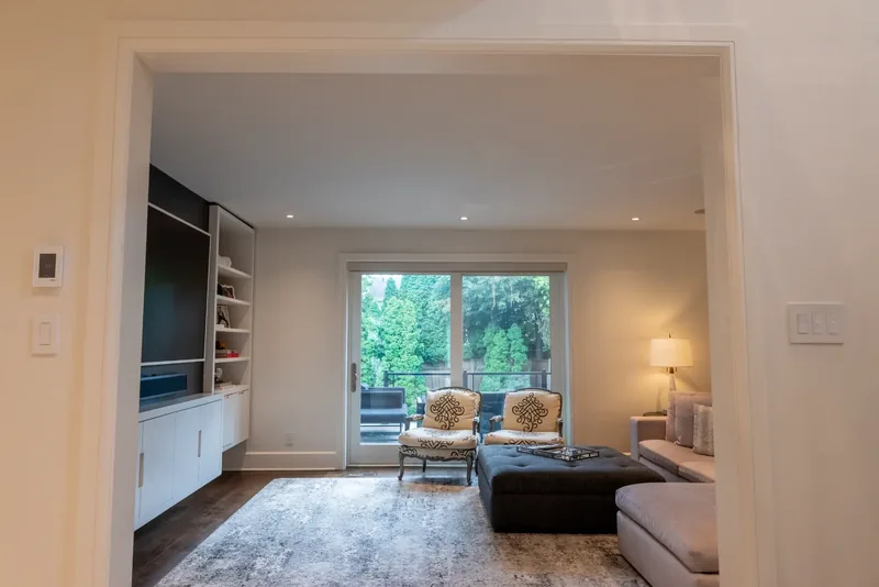 Family room with a sectional sofa, a tufted ottoman, and garden doors
