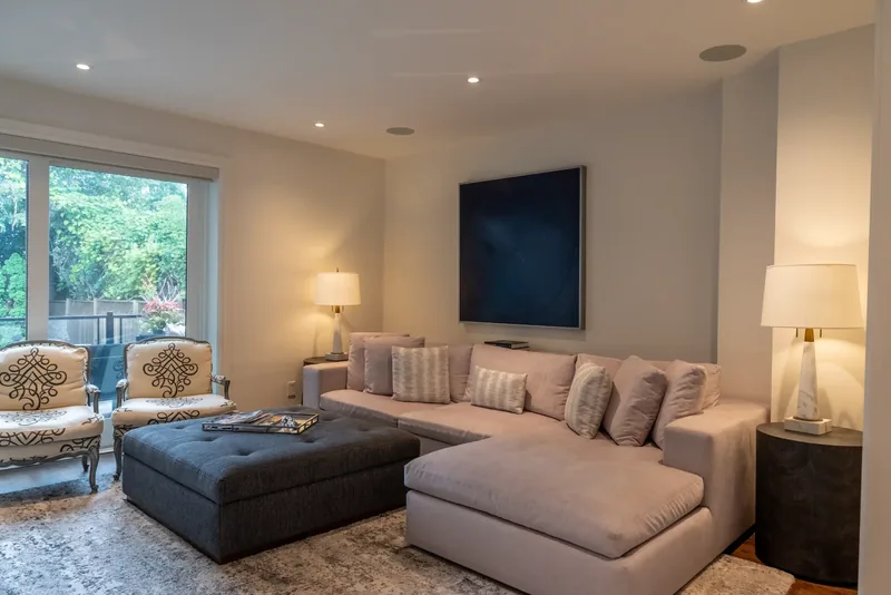 Family room with a sectional sofa, a tufted ottoman, and garden doors