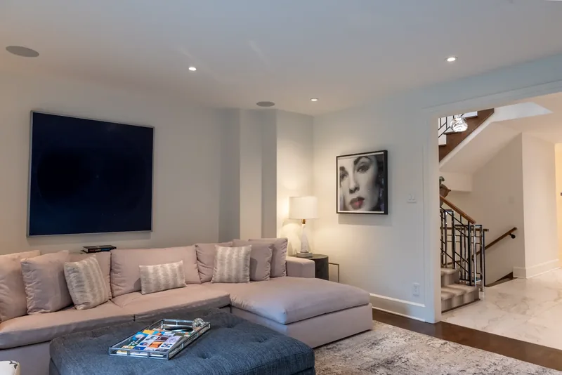 Family room with a sectional sofa, a tufted ottoman, and garden doors