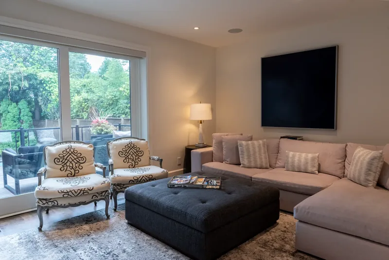 Family room with a sectional sofa, a tufted ottoman, and garden doors