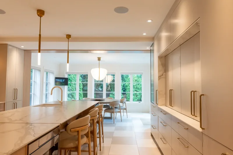 Kitchen island opening onto a bright breakfast area overlooking the garden