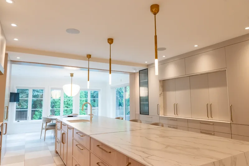 Kitchen island opening onto a bright breakfast area overlooking the garden