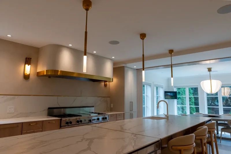 Kitchen island and range wall with a brass-banded hood