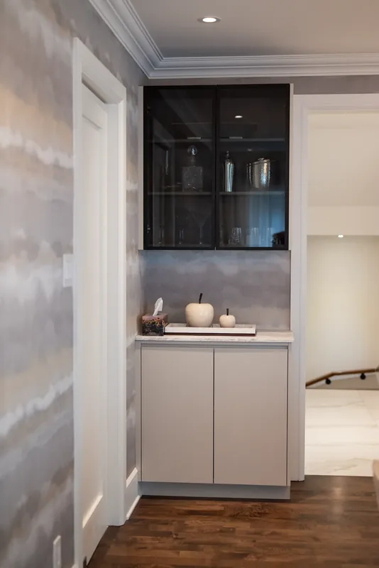 Built-in bar niche with a glass-front cabinet beside the dining room
