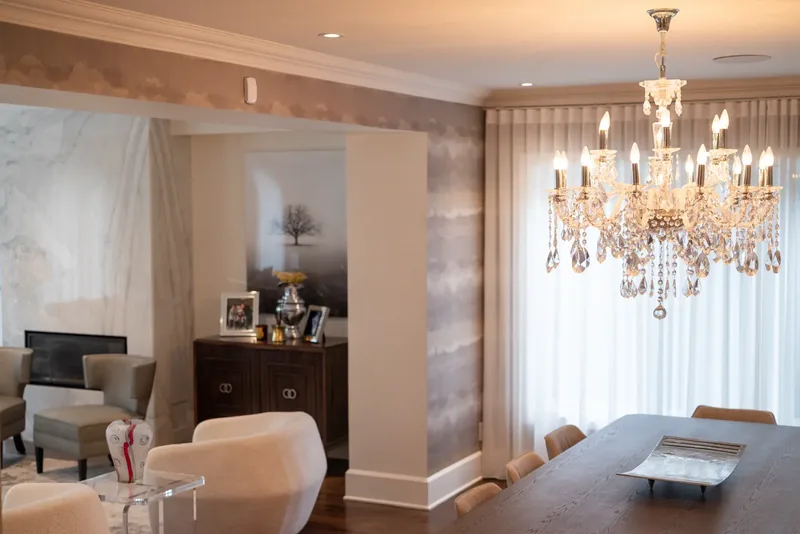 Dining room with a crystal chandelier, textured wallcovering, and a long table