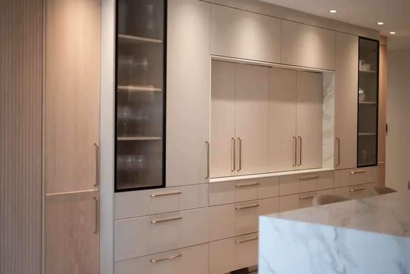 Floor-to-ceiling cabinetry with glass-front display units