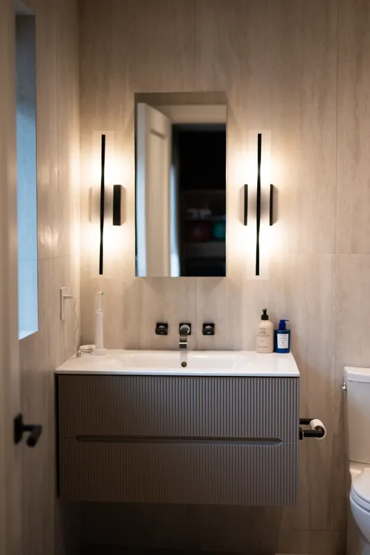 Shower room with a floating vanity and black wall sconces