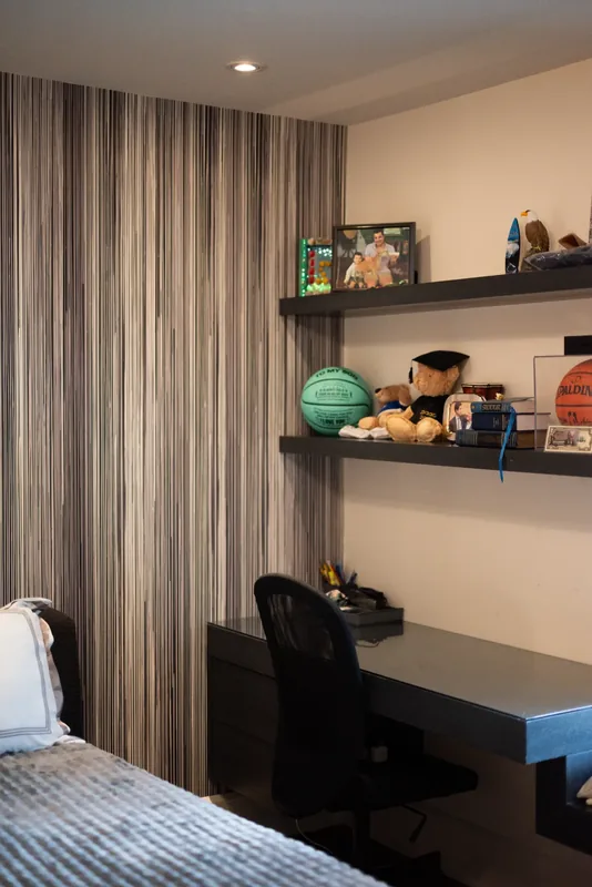 Bedroom desk with floating shelves and a striped drapery wall