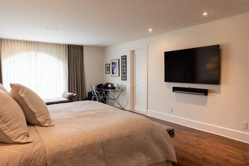 Primary bedroom with an arched window and full-height drapery