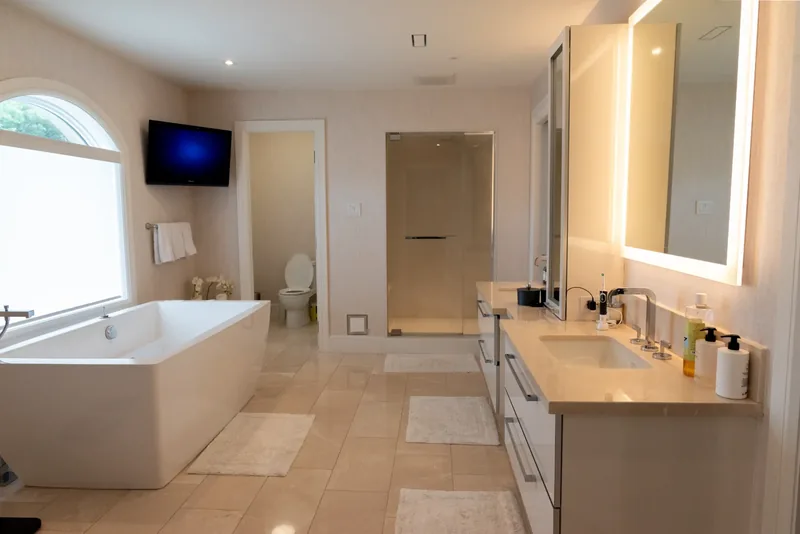 Primary ensuite with a double floating vanity and backlit mirrors