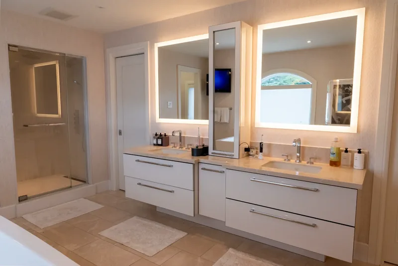 Primary ensuite with a double floating vanity and backlit mirrors