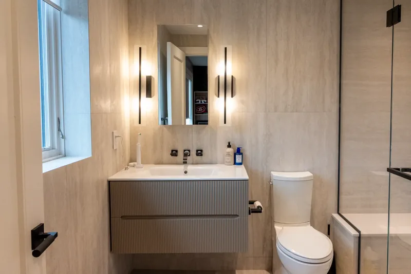 Shower room with a floating vanity and black wall sconces