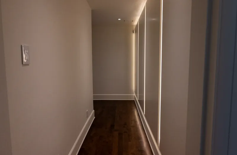 Corridor with integrated linear lighting along the closet wall