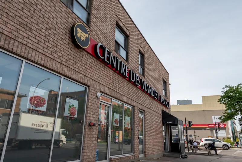 Two-storey brick corner store with red channel-letter signage, the round Iasenza logo, and tall storefront windows