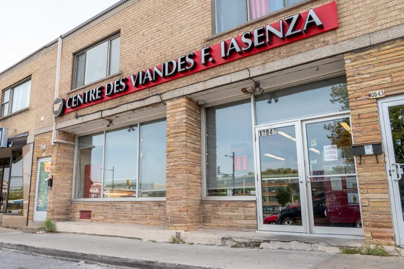 Street-front Iasenza store with a tan brick and stone facade, a red sign, and glass double doors