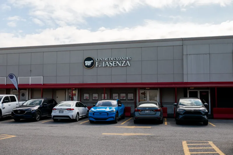 Large standalone Iasenza store clad in grey metal panels, with a red band, a logo sign, and a full parking lot