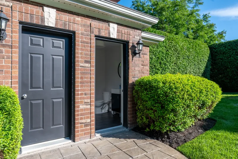 Garden pavilion doors with brick walls and clipped shrubs