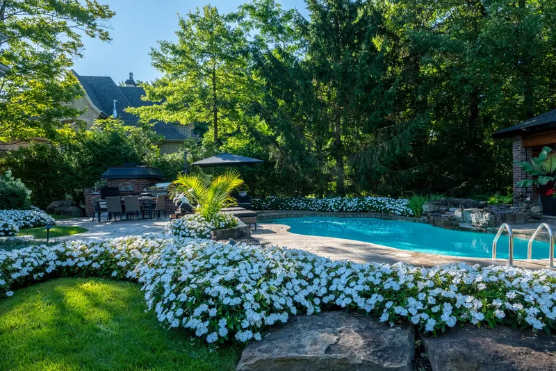 Stone terrace with natural rock edging and drifts of white flowers
