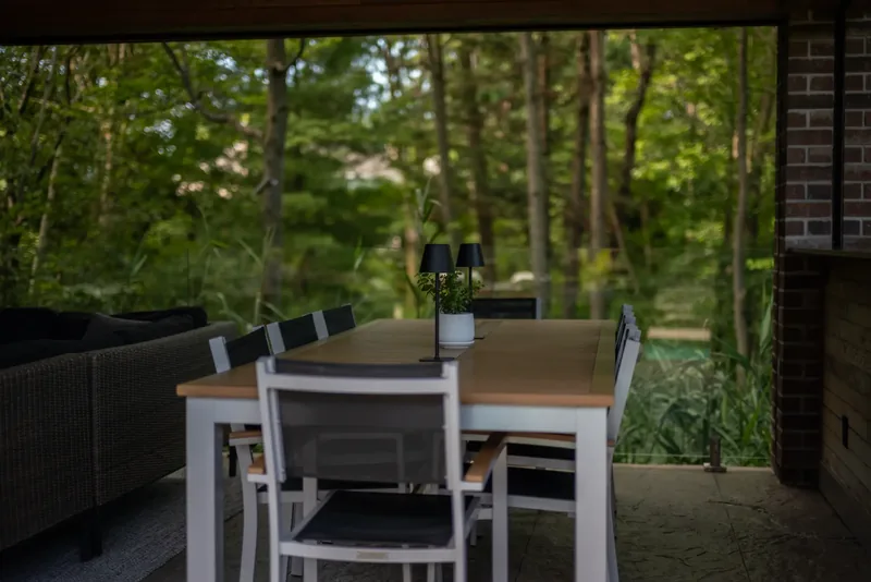 Long dining table and bar counter in the pavilion facing the woods