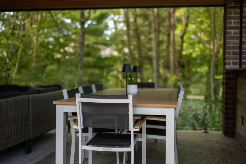 Long dining table and bar counter in the pavilion facing the woods