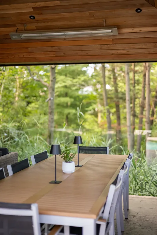 Long dining table and bar counter in the pavilion facing the woods