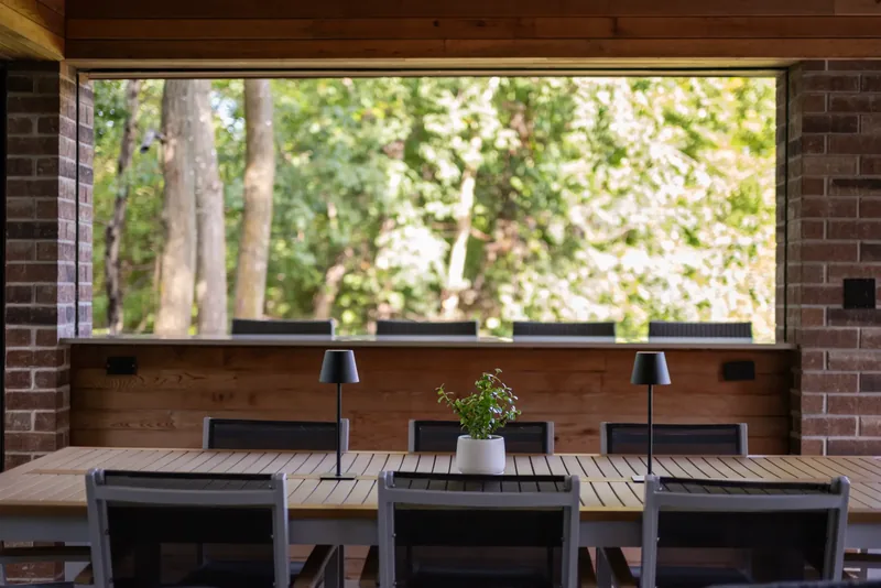 Long dining table and bar counter in the pavilion facing the woods